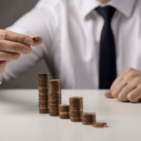 businessman-adding-coin-stack